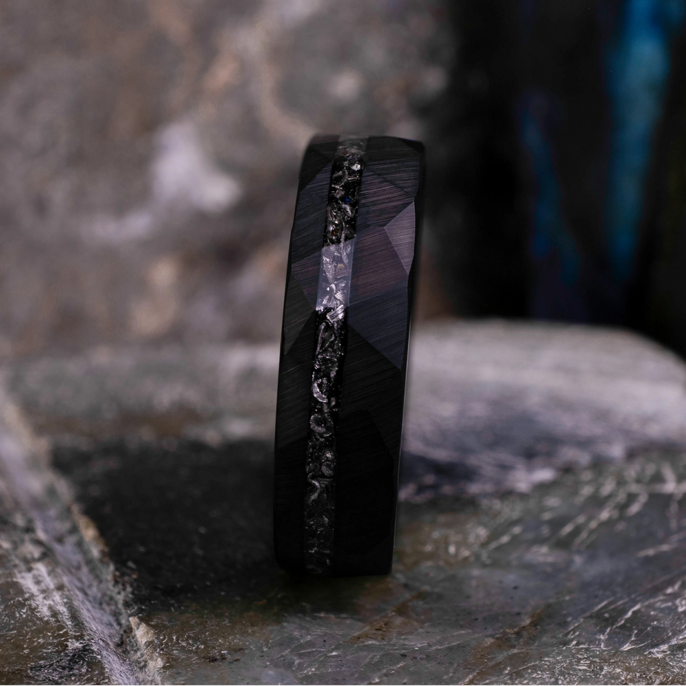 6mm black hammered tungsten carbide wedding band with a crushed meteorite stripe,  on top a large grey stone. 