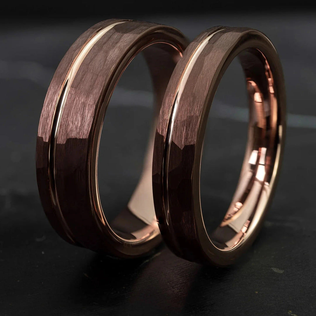 Hammered His and Hers mocha brown with a stripe and rose gold interior, on top of a dark stone.