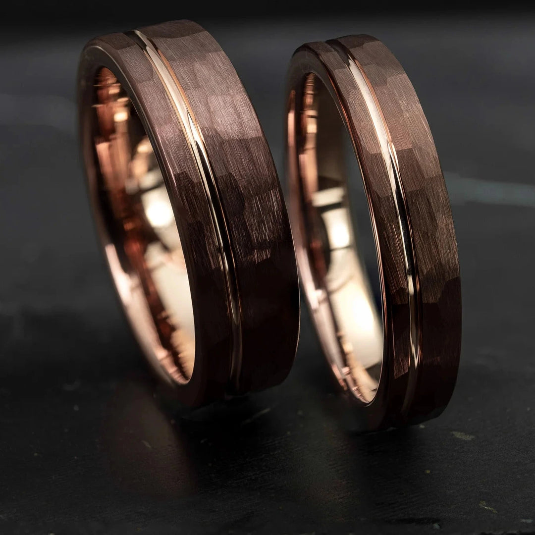 Hammered His and Hers mocha brown with a stripe and rose gold interior, on top of a dark stone.