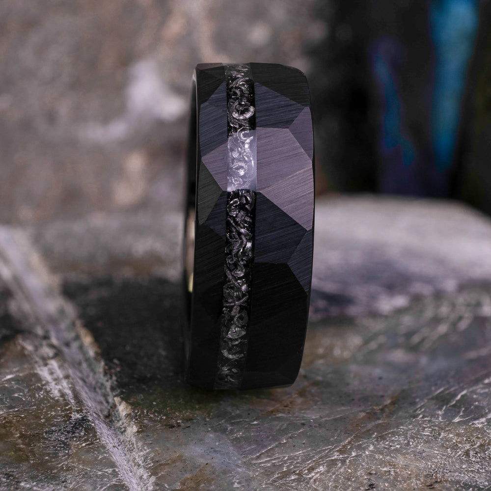 8mm black hammered tungsten carbide wedding band with a crushed meteorite stripe,  on top a large grey stone. 