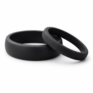 Two black silicone bands on a white surface.